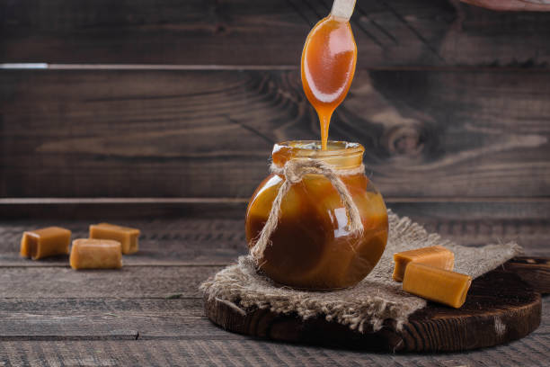 salsa de caramelo salado casero en el tarro en el fondo de la mesa de madera rústica. copia espacio. - chocolate pot de creme fotografías e imágenes de stock