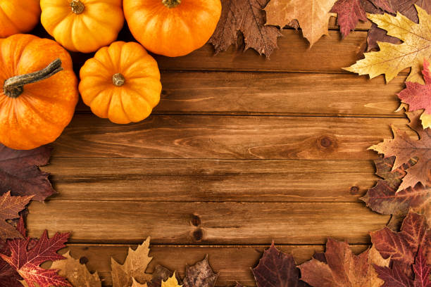 istock Pumpkins with fall leaves over wooden background. Top view. 899401784