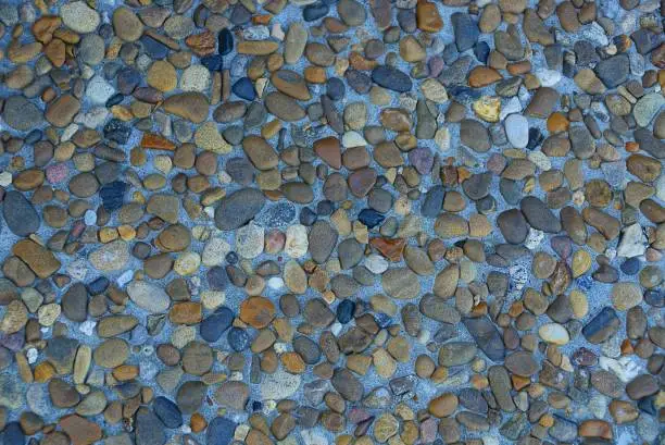 Photo of colored pebbles and crushed stone in cement on the foundation