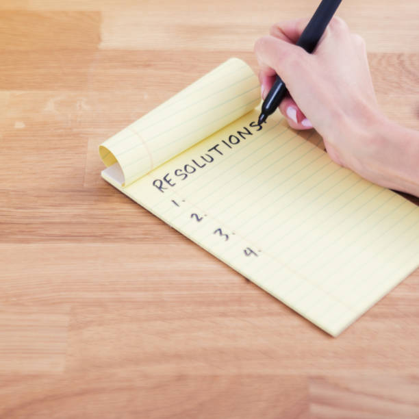 istock Unrecognizable woman writes New Year resolutions 899406596