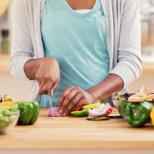 istock Confident woman slices onion for salad 899406646