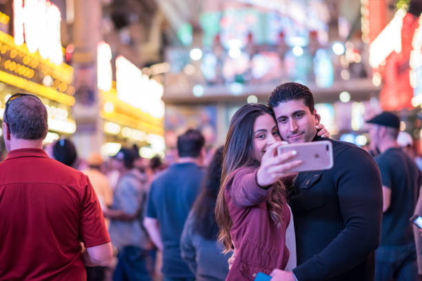 beautiful couple taking a selfie at fremont street experience, downtown las vegas - downtown las vegas fremont street experience nevada las vegas metropolitan area imagens e fotografias de stock