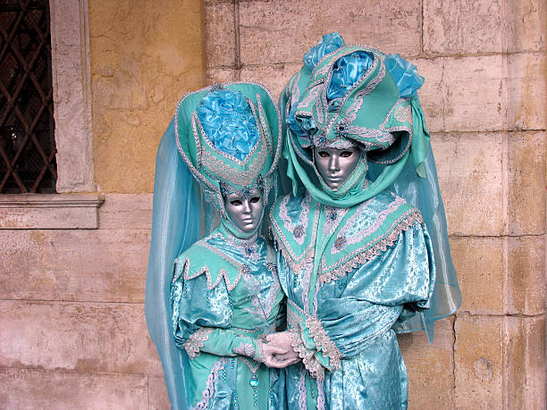 Venice Carnival: Couple in turquoise costumes, holding hands stock photo