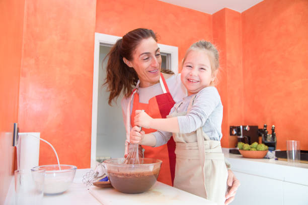 istock happy child whipping chocolate with mother 899415534