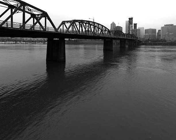 The St. Johns Railroad Bridge aka the Willamette River Railroad Bridge that spans the Willamette River in Portland, Oregon. Behind it and only partly visible, is downtown Portland, Oregon. Edited.