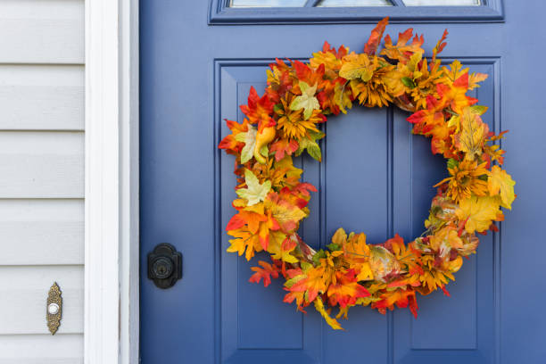 Orange and yellow autumn wreath on blue door Closeup of front door and decorative autumn wreath blue house red door stock pictures, royalty-free photos & images
