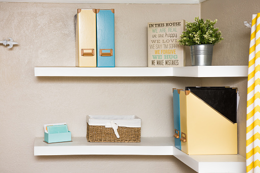 Two white floating shelves simply decorated with yellow and blue