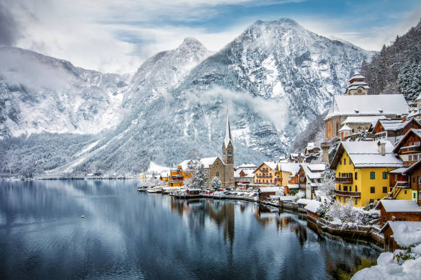 das verschneite dorf von hallstatt in den österreichischen alpen - winter lake snow water stock-fotos und bilder