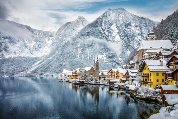 il villaggio innevato di hallstatt nelle alpi austriache - church in the snow foto e immagini stock