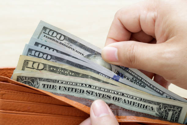 istock Hand holding wallet with US Dollar banknote and taking out money from wallet. 899428034