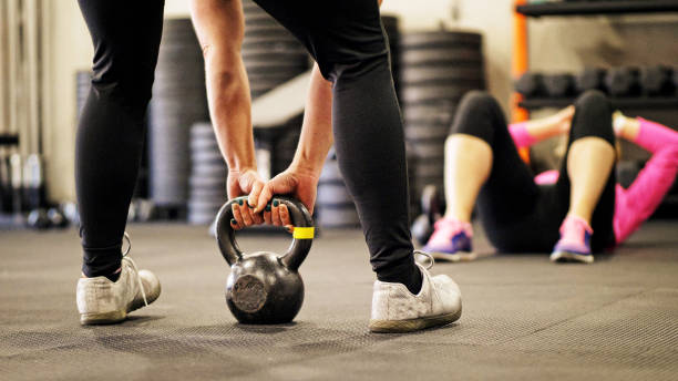 istock Woman lifting kettlebell in gym. 899431658