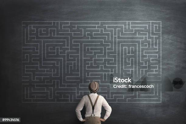 Man Try To Solve A Labyring On A Chalkboard Stock Photo - Download Image Now - Maze, Challenge, Lost