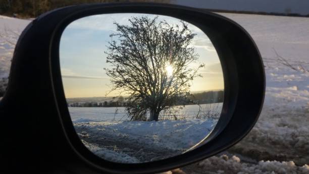 reflexo de uma árvore e o sol em um dia de neve em um espelho de asa de carros. - car winter road reflector snow - fotografias e filmes do acervo