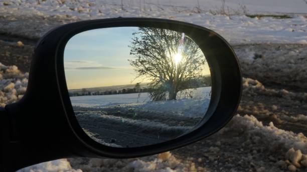 reflexo de uma árvore e o sol em um dia de neve em um espelho de asa de carros. - car winter road reflector snow - fotografias e filmes do acervo