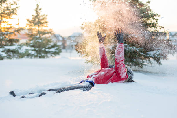 Winter time retreat - girl playing in the deep snow in sunset Cheerful spirit in vacation time after heavy snow fall. snowshoeing snow shoe red stock pictures, royalty-free photos & images