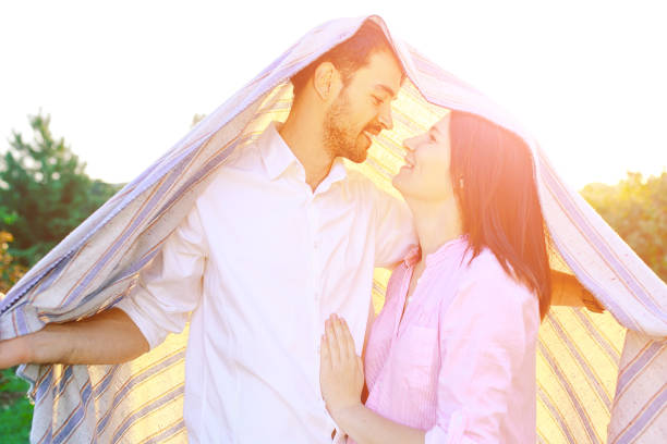 istock Happy couple portrait wrapped in a blanket 899464636