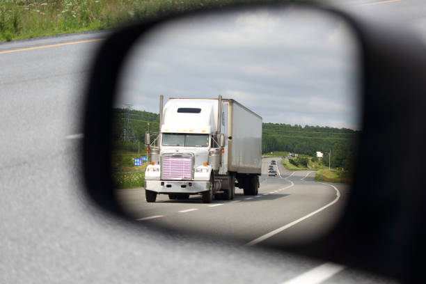 istock Semi-truck on a highway seen through a mirror 899467866