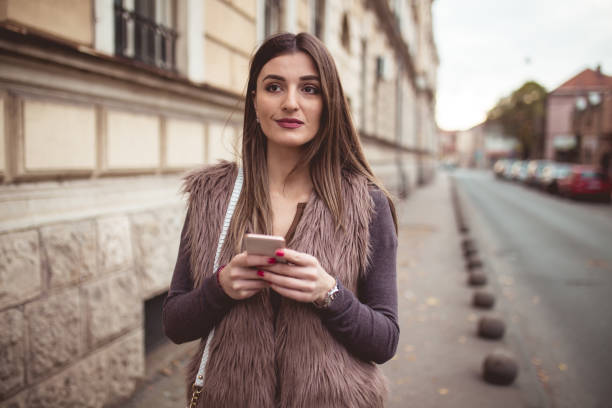 istock Cute lady texting on mobile phone outdoor 899471758