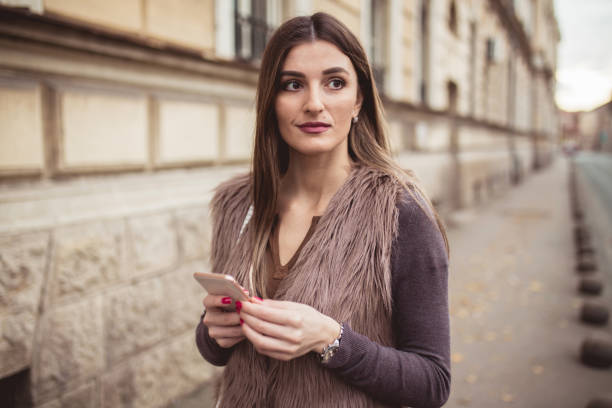 istock Young lady using mobile phone on the street 899471848