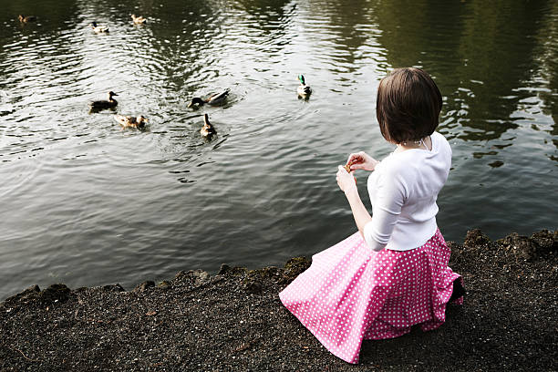 istock Young Woman Feeding Ducks In Color. 89947588