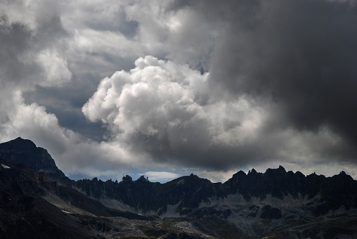 Window of blue sky in the Swiss alps and dark cloudy sky