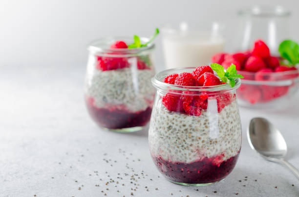istock Two glass jars with chia pudding with raspberry and jam. Bowl of 899483502