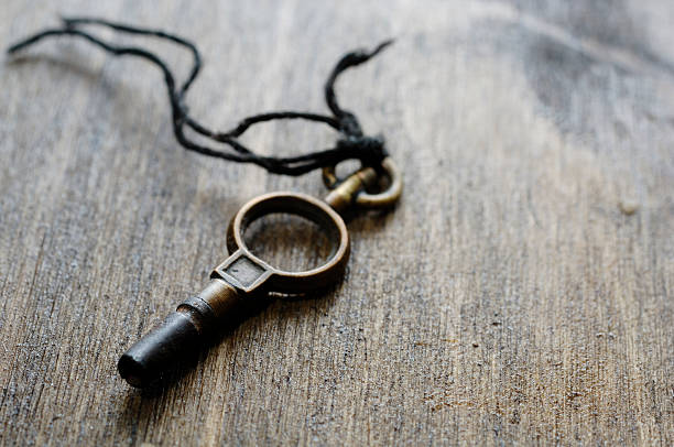 istock Old antique clock key against dark oak shallow focus 89948937