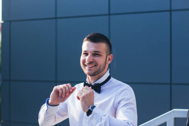istock Young stylish man tied bow tie. 899503330
