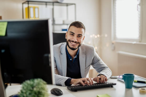 istock Young businessman working in his office, typing on a keyboard 899503812
