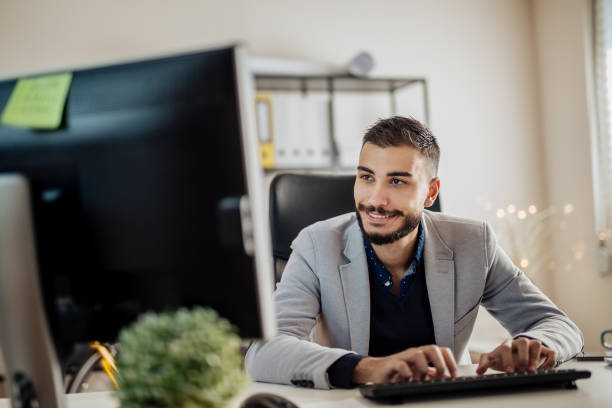 istock Young businessman working in his office, typing on a keyboard 899503940