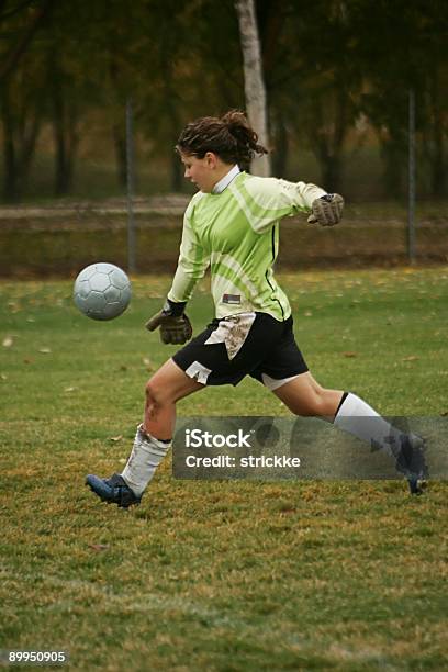 Femmina Portiere In Verde Agressively Akick Ball - Fotografie stock e altre immagini di Bambino - Bambino, Calcio - Sport, Determinazione