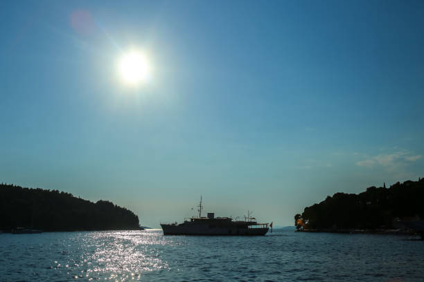Silhouette of a boat in front of the coast in Cavtat, Croatia.\
