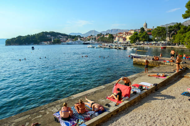 Cavtat, Croatia - July 20, 2017 : People swimming and sunbathing on the coast of Cavtat, Croatia.