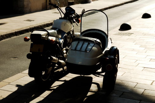 Closeup black moto helmet on motorcycle handlebars against blurred background