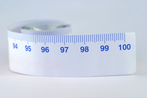 Close up view of green measuring tape. Diet, weight loss and fasting