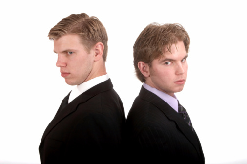 Two young businessmen watch each other's backs. I got your back.