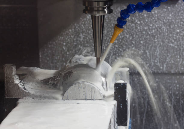 istock CNC machining Center is cutting part with white coolant 899563420