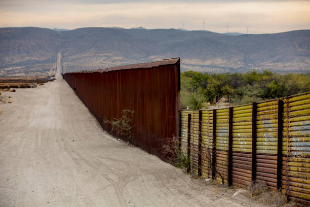 Border Wall Section Between United States and Mexico A lengthy section of the United States border wall with Mexico in California international border barrier stock pictures, royalty-free photos & images