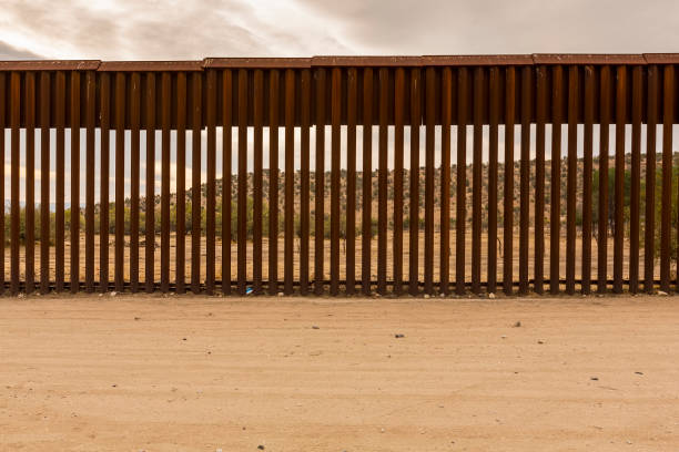 United States Border Wall with Mexico View of Mexico through international border wall at Jacumba California international border barrier stock pictures, royalty-free photos & images