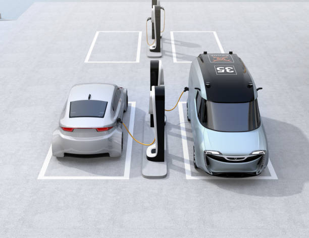 istock Electric delivery minivan and silver sedan charging at charging station 899584876