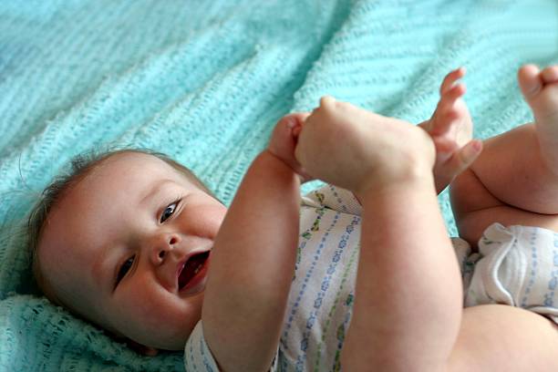 Baby playing with toes stock photo