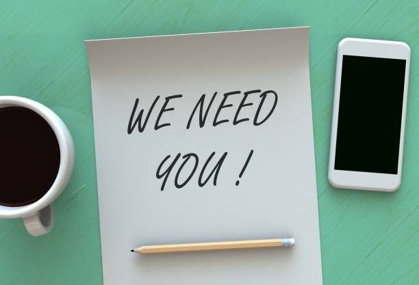 istock WE NEED YOU, message on paper, smart phone and coffee on table 899593124