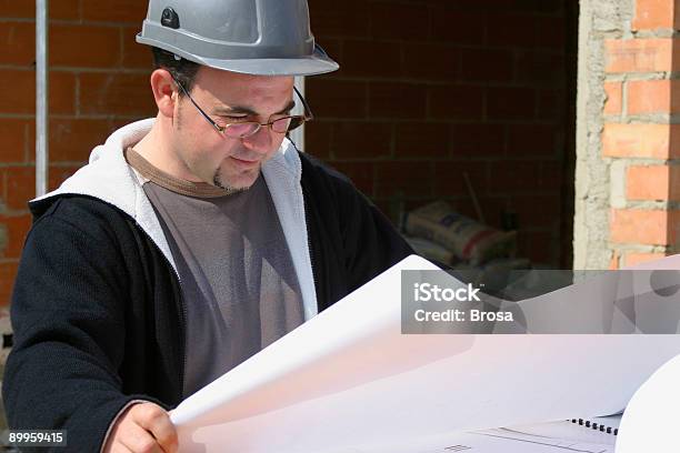 Arquitecto Revisando Planes Foto de stock y más banco de imágenes de Accesorio de cabeza - Accesorio de cabeza, Actividad, Adulto