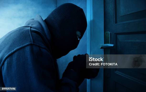 Masked Thief Using Lock Picker To Open Locked Door Stock Photo - Download Image Now - Thief, Burglary, Burglar