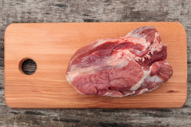 istock Raw pork meat on cutting board on a table. Top view 899597556