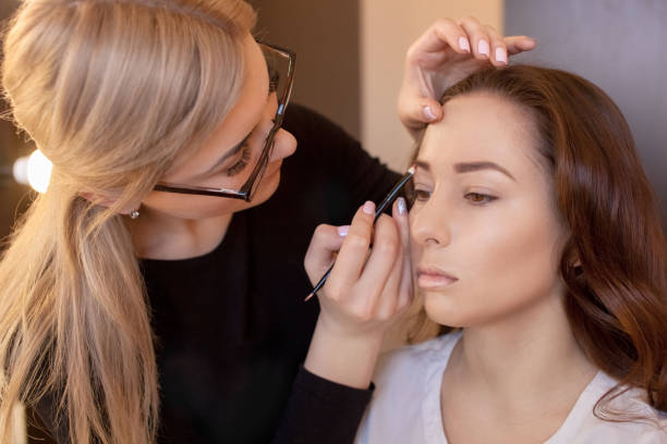 istock The make-up artist paints eyebrows with brush 899602374