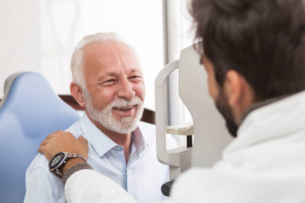 senior patient consulting with optician in office - patient happiness cheerful optometrist imagens e fotografias de stock