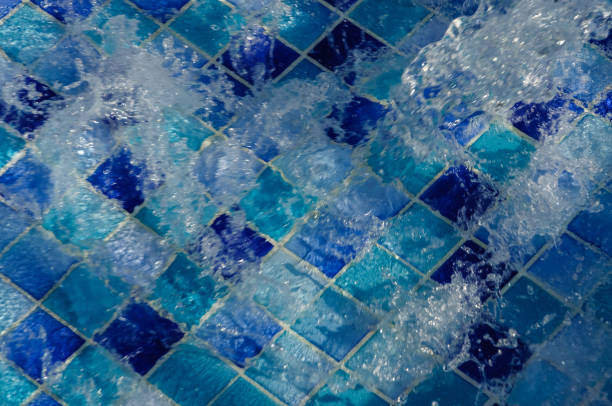 istock Water flows into the swimming pool with sunny reflections 899615386