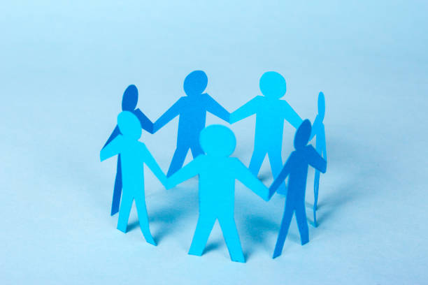 istock Paper men are holding hands standing in a circle. Teamwork, family, support. Blue background 899619802