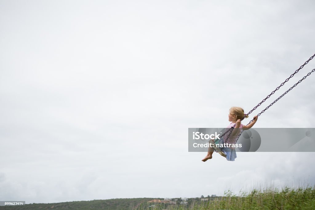 Kleines Kind schwingt auf einer Holzschaukel - Lizenzfrei Kind Stock-Foto